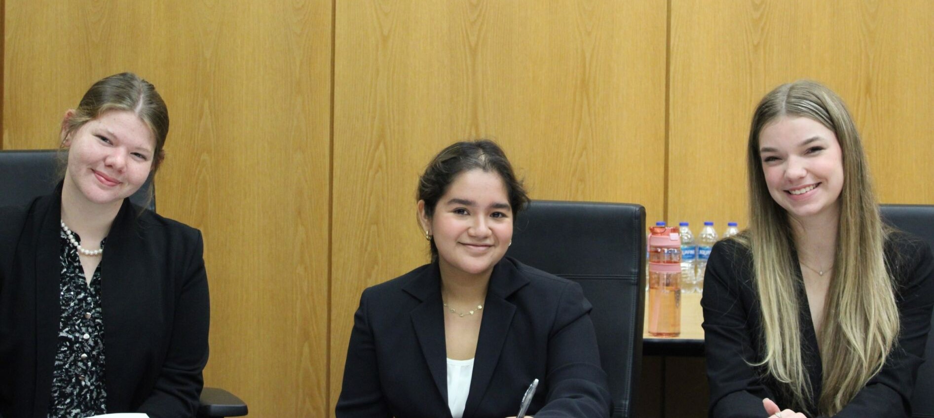 Three students from George Jenkins High School sitting at attorney tables